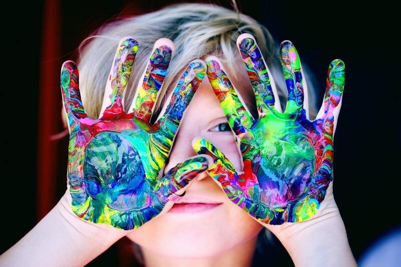 Criança com as mãos cobertas de tinta colorida, imagem original do artigo Amor Próprio